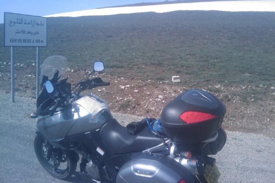 bike parked by the side of the road with a clear snow line not far away